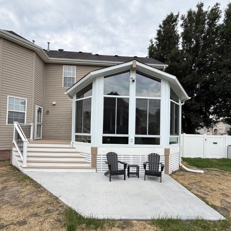 ModExt sunroom addition with tall windows and patio seating